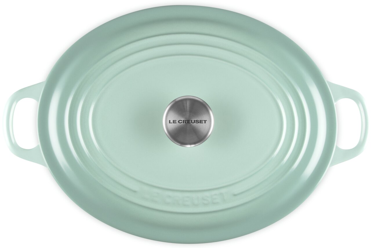 Mintgrüner ovaler Le Creuset Bräter mit Deckel und seitlichen Griffen, Draufsicht von oben auf weißem Hintergrund
