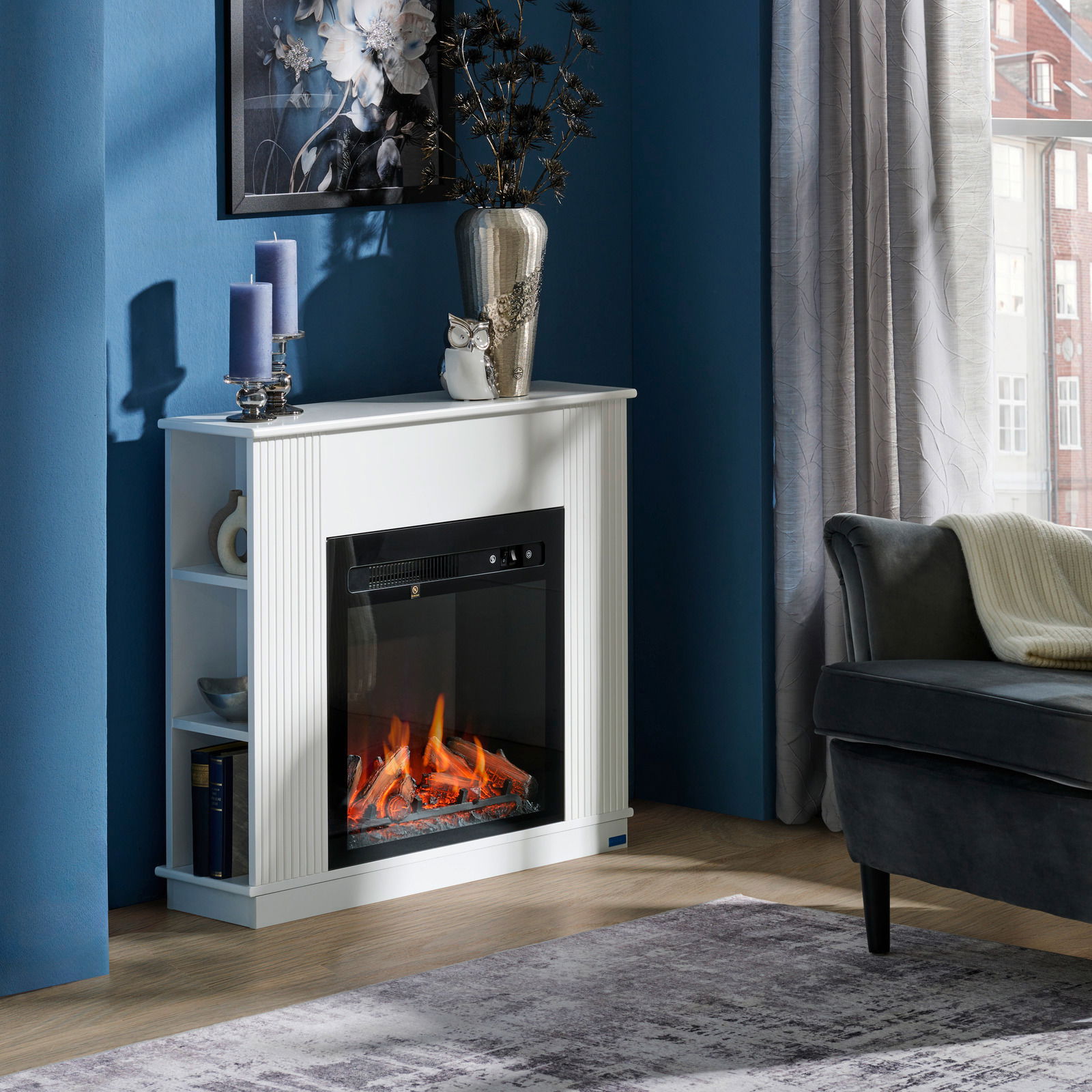 Elektrokamin in einem modernen Wohnzimmer, frontal fotografiert, mit dekorativen Elementen wie Kerzen und einer Vase auf dem Kaminsims.