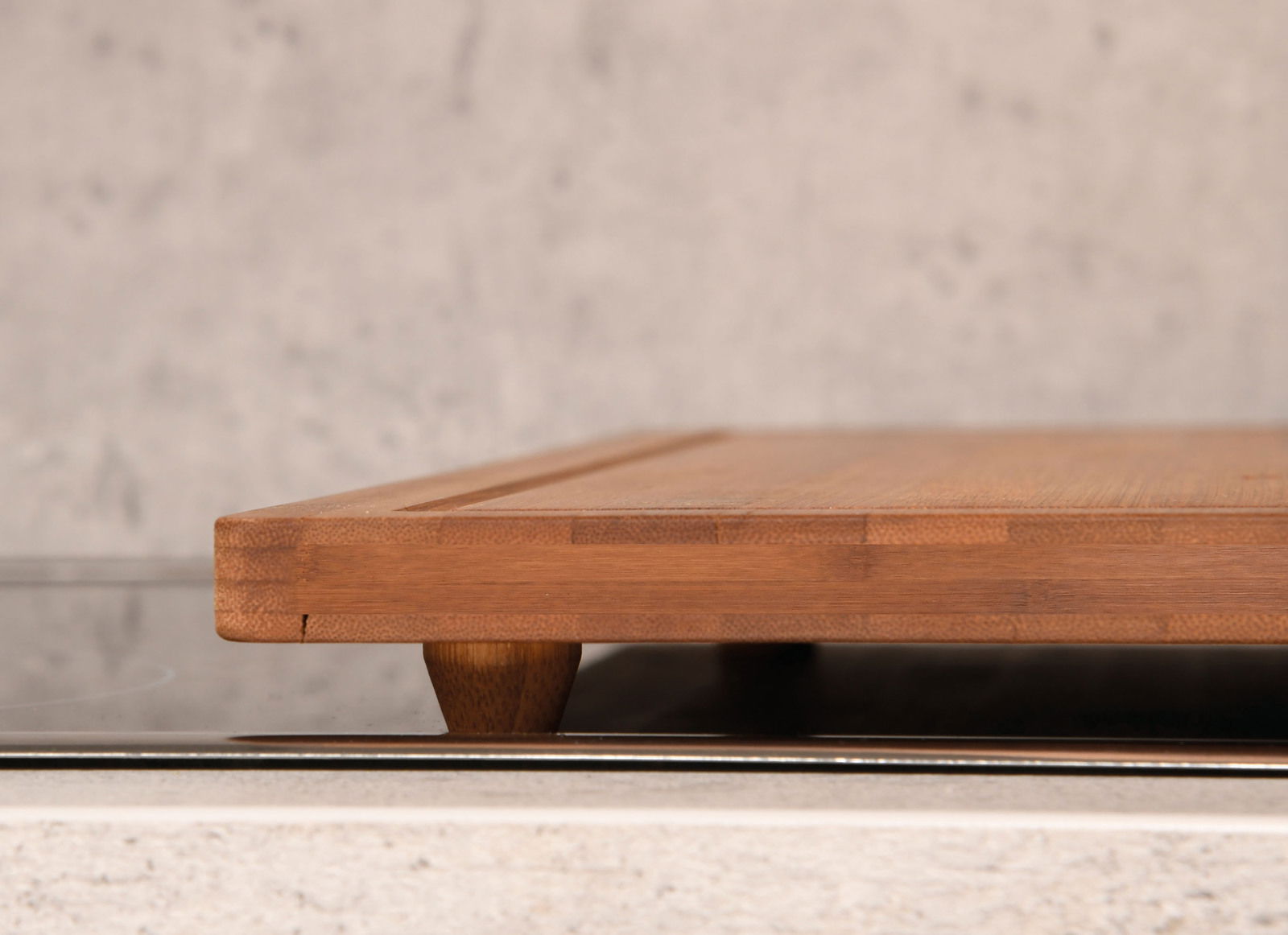 Seitenansicht einer Schneide- und Abdeckplatte aus Holz auf einer Küchenarbeitsfläche.