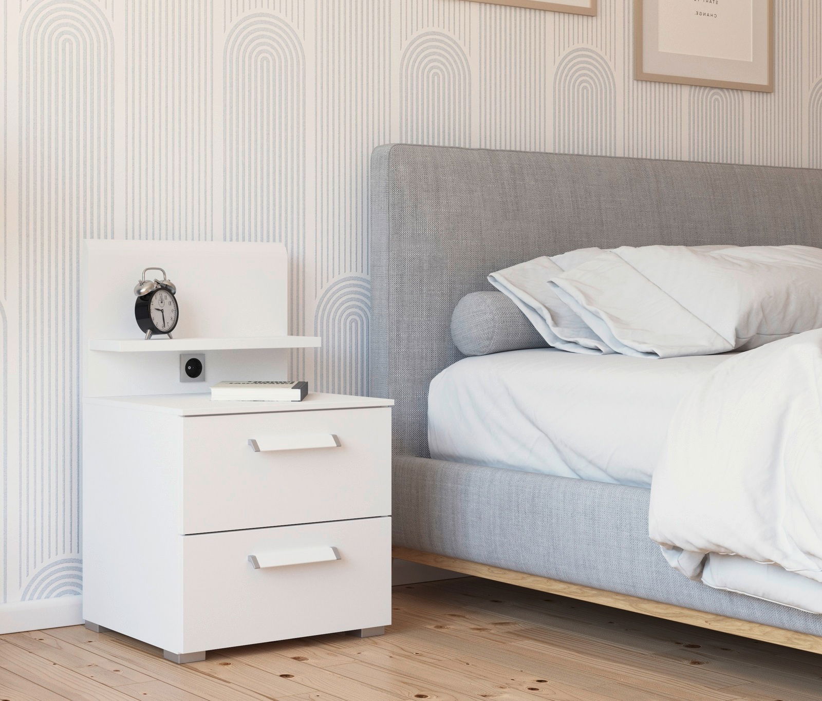 Weißes Nachttisch-Paneel mit zwei Schubladen, einem Regal und einer Steckdose, seitliche Perspektive neben einem grauen Bett.