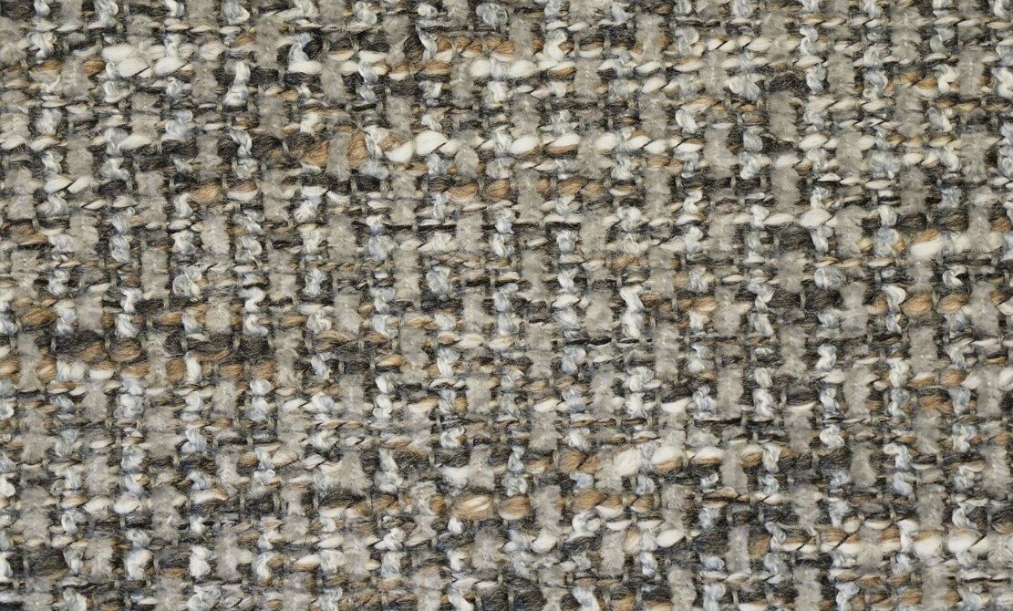 Close-up van een gestructureerd stofpatroon in grijze en beige tinten, gebruikt voor een longchair-set.