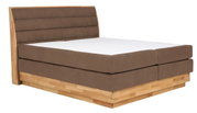 Boxspringbed in zijaanzicht met bruine stoffen bekleding en houten frame