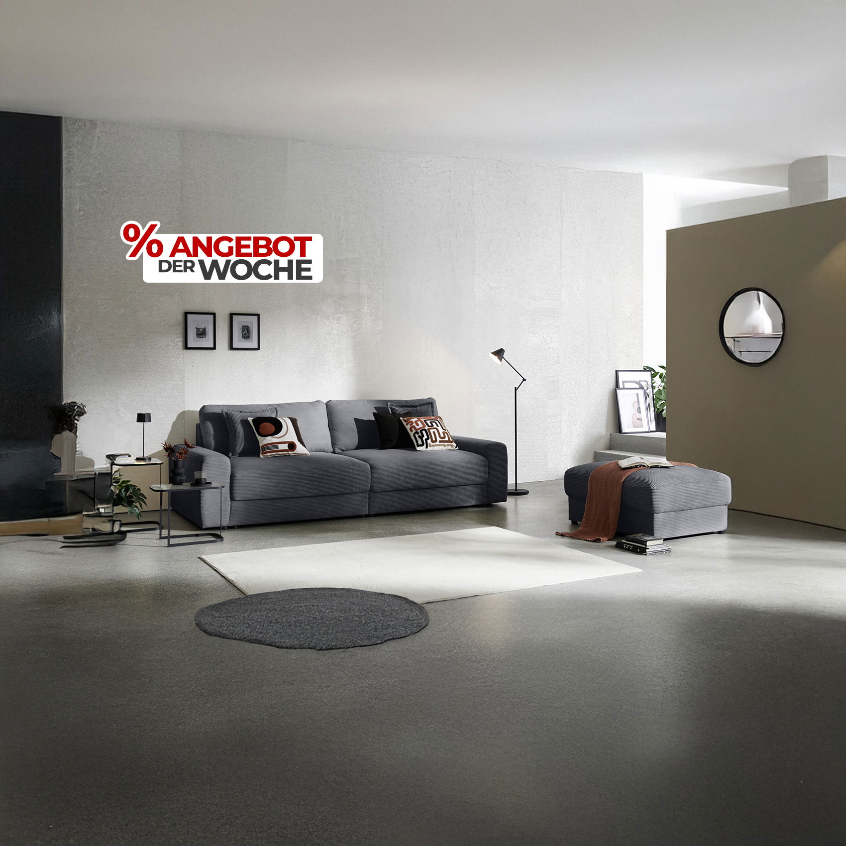 Modernes Wohnzimmer mit grauem Sofa und Hocker, schlichter Deko und Schriftzug „Angebot der Woche“