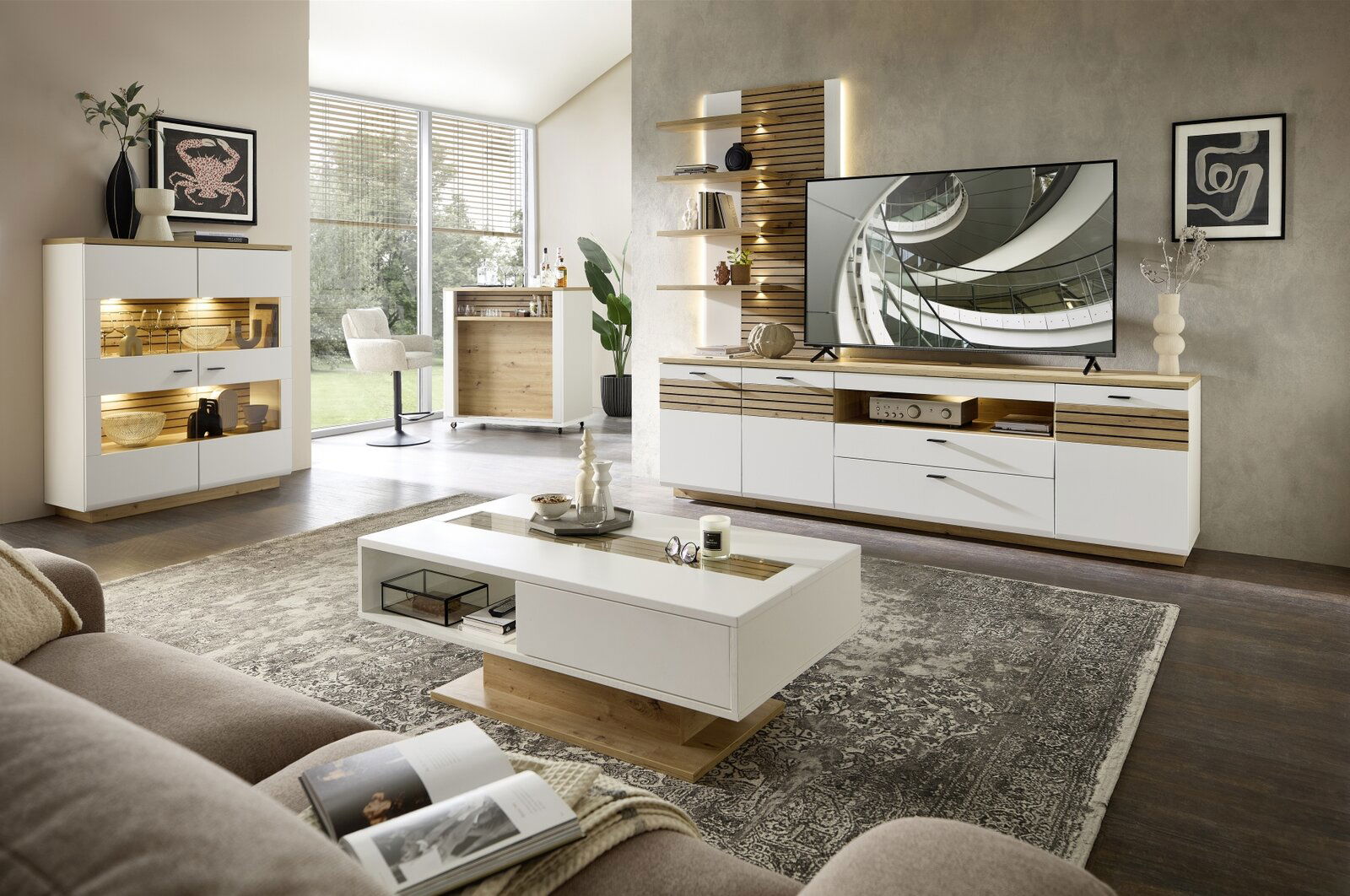 Moderne Wohnzimmer-Wandkombination in hellem Holz und Weiß, mit TV, Regalen und dekorativen Elementen, aus der Perspektive eines gemütlichen Wohnzimmers.