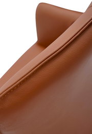 Nahaufnahme eines braunen Armlehnstuhls aus Leder, seitliche Perspektive