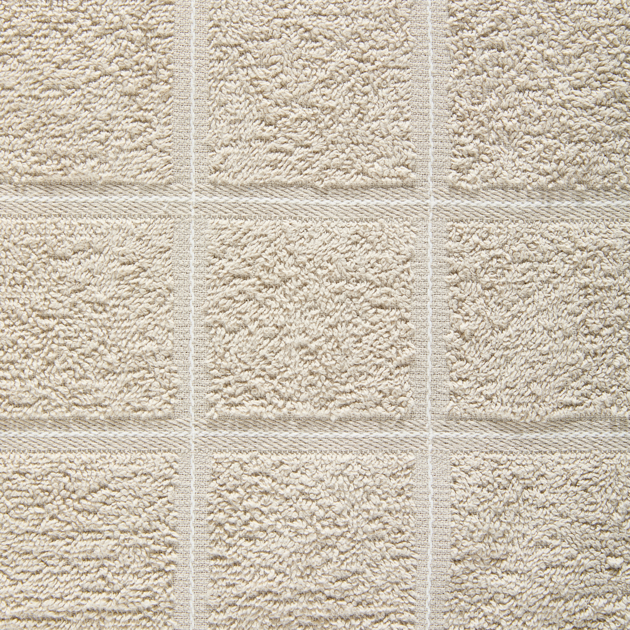 Nahaufnahme eines beigen Frottierhandtuchs mit quadratischem Muster