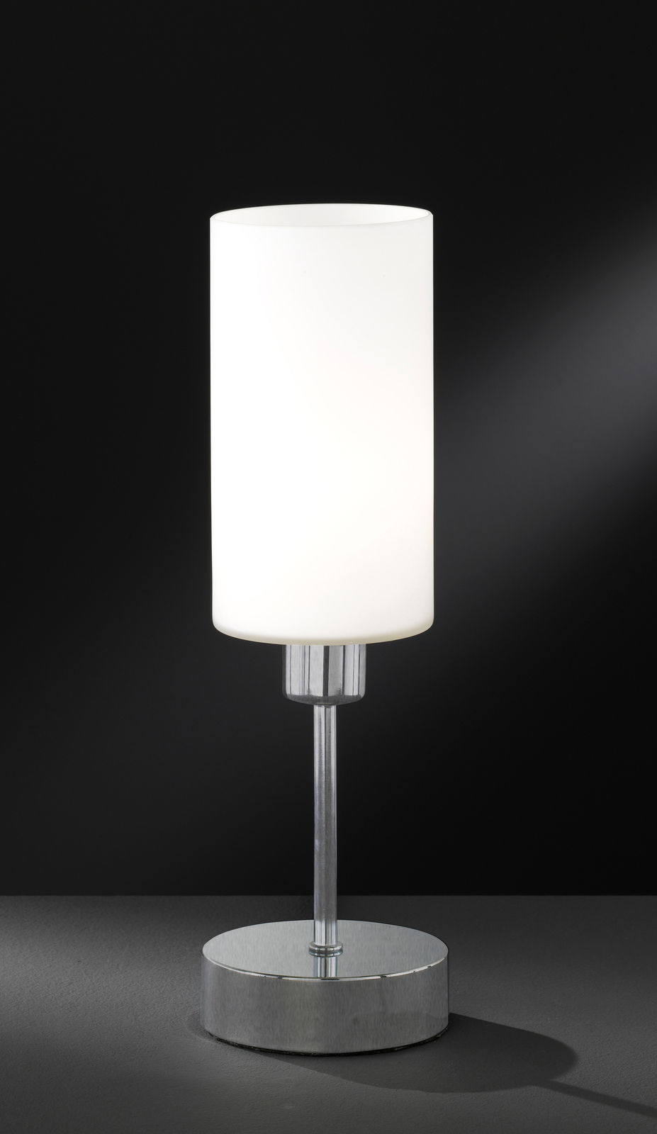 Moderne Tischleuchte mit zylindrischem, weißem Lampenschirm und verchromtem Sockel, seitliche Perspektive