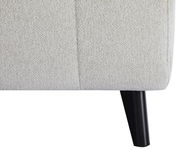 Nahaufnahme eines Funktionssofas mit hellbeigem Stoffbezug und schwarzem Holzbein, seitliche Perspektive