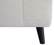 Nahaufnahme eines Funktionssofas mit hellbeigem Stoffbezug und schwarzem Holzbein, seitliche Perspektive