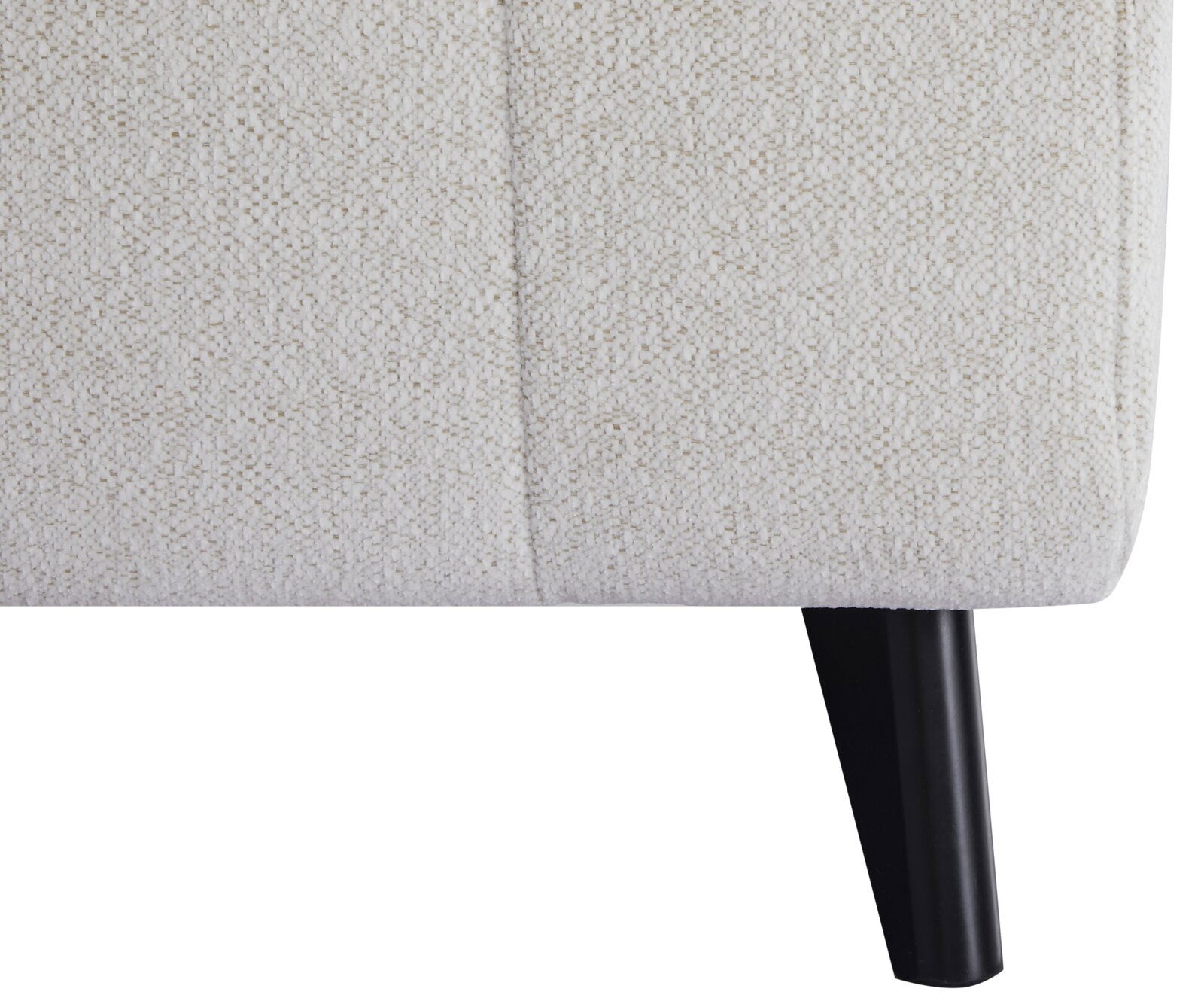 Nahaufnahme eines Funktionssofas mit hellbeigem Stoffbezug und schwarzem Holzbein, seitliche Perspektive