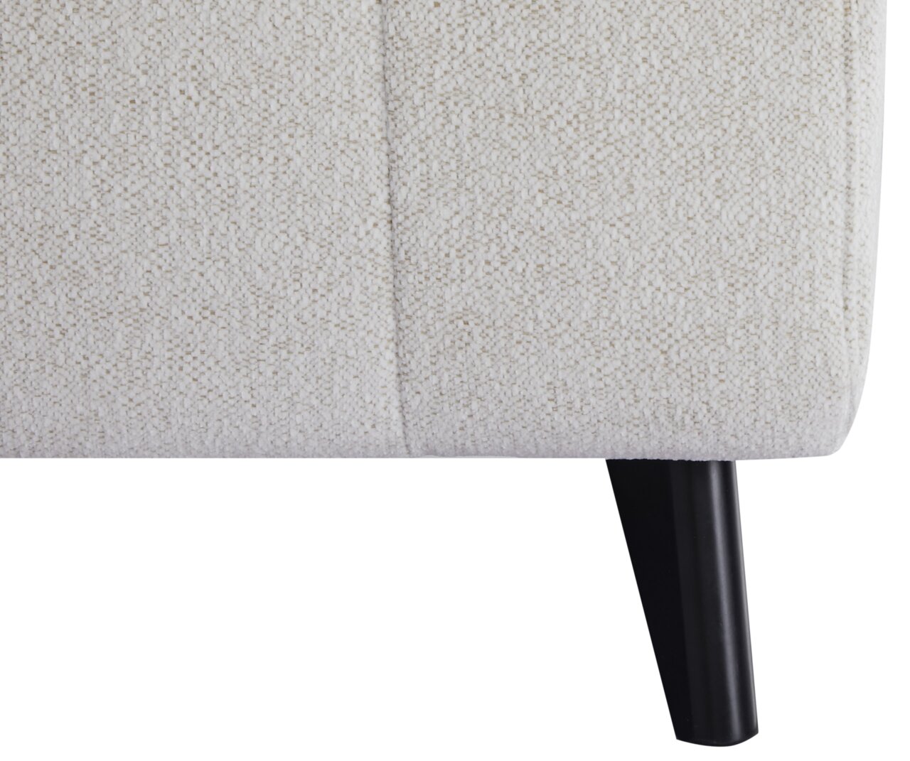 Nahaufnahme eines Funktionssofas mit hellbeigem Stoffbezug und schwarzem Holzbein, seitliche Perspektive