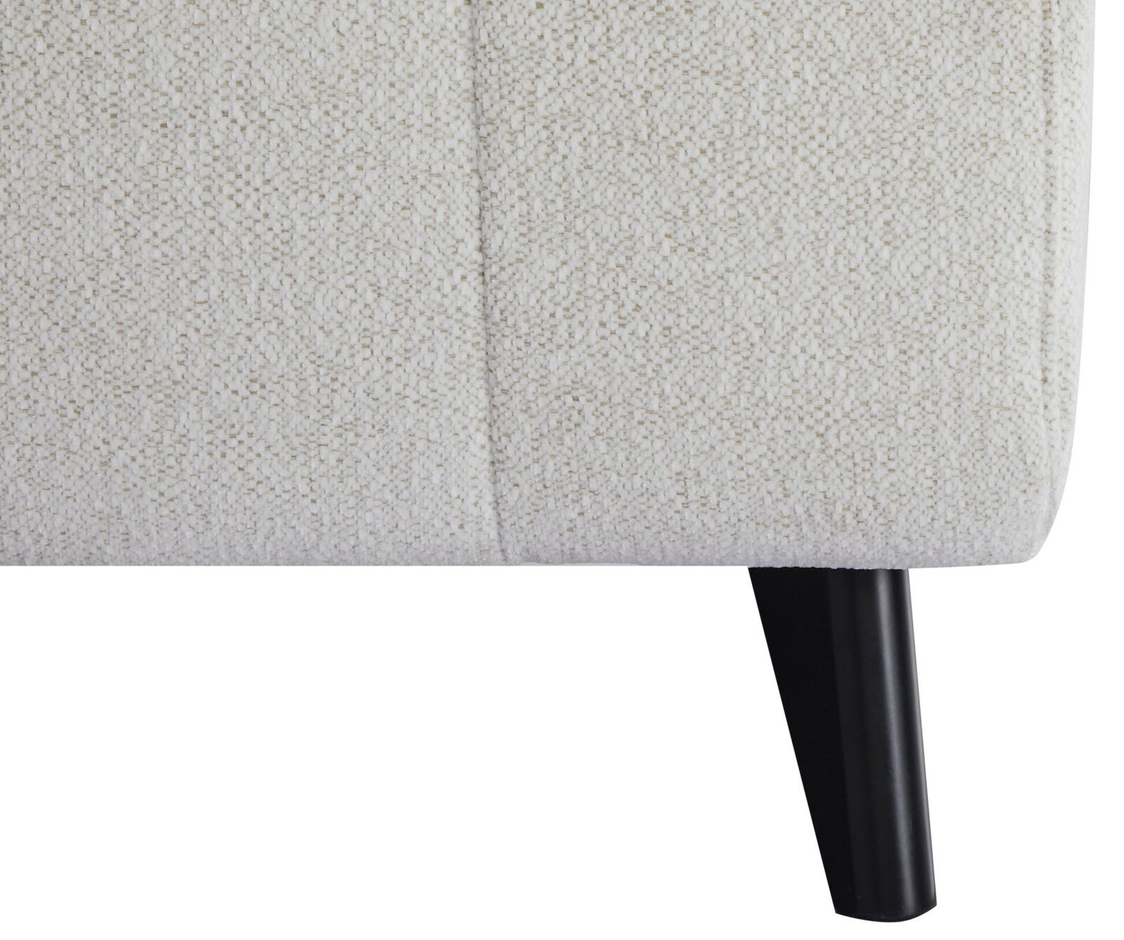 Nahaufnahme eines Funktionssofas mit hellbeigem Stoffbezug und schwarzem Holzbein, seitliche Perspektive