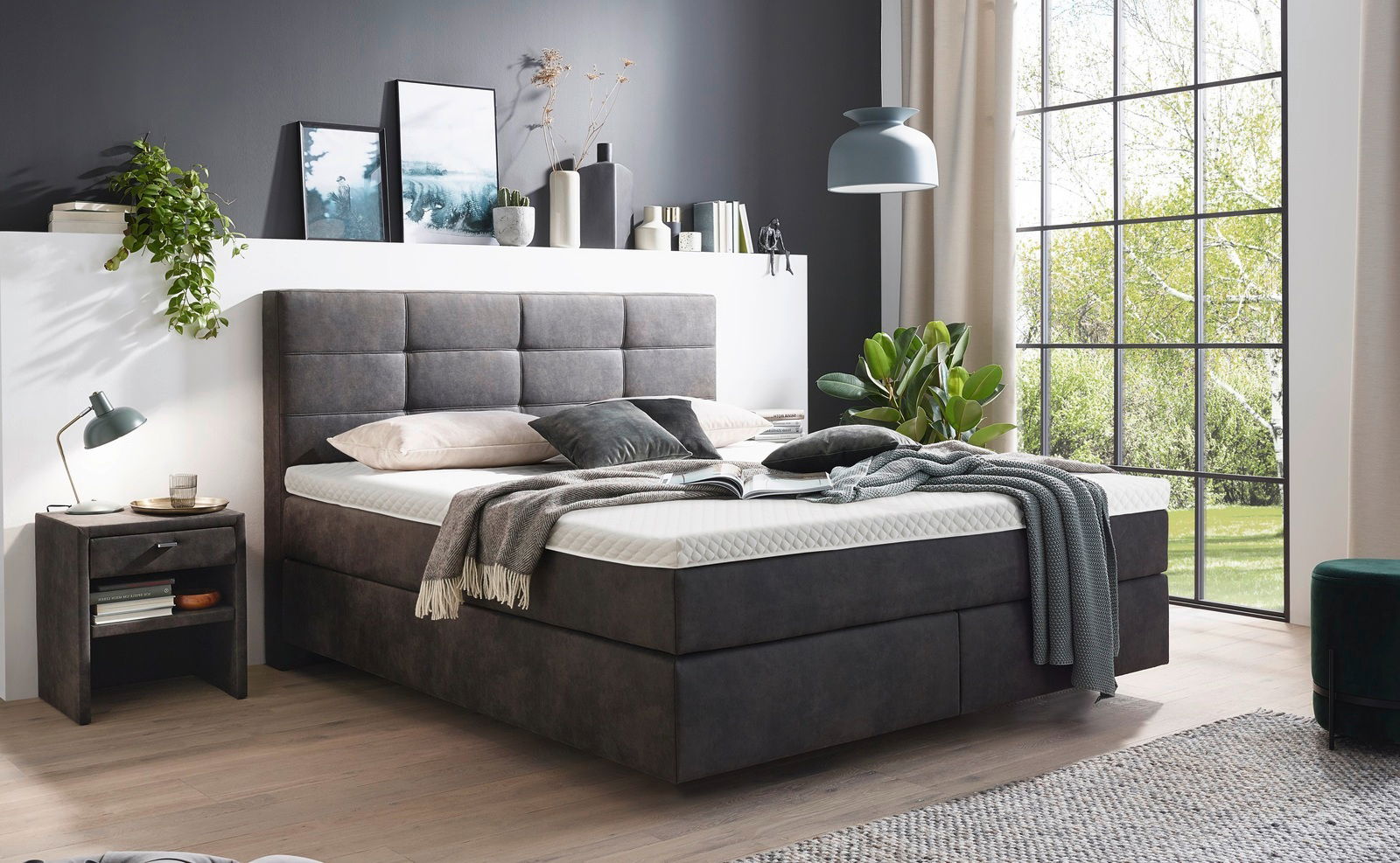 Modernes Boxspringbett in einem stilvoll eingerichteten Schlafzimmer, seitliche Perspektive