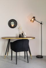 Moderne Stehleuchte in schwarzem Design, seitliche Perspektive neben einem eleganten Tisch mit Dekoration.
