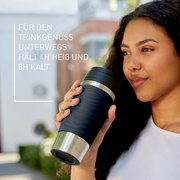 Frau hält einen schwarzen Thermobecher Classic Wave 0,36L in der Hand, seitliche Perspektive