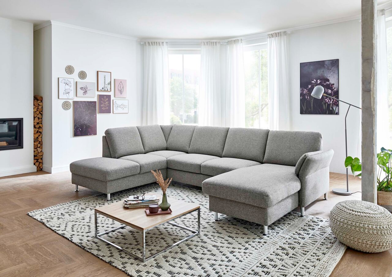 Graue Polsterrundecke in einem modernen Wohnzimmer, seitliche Perspektive