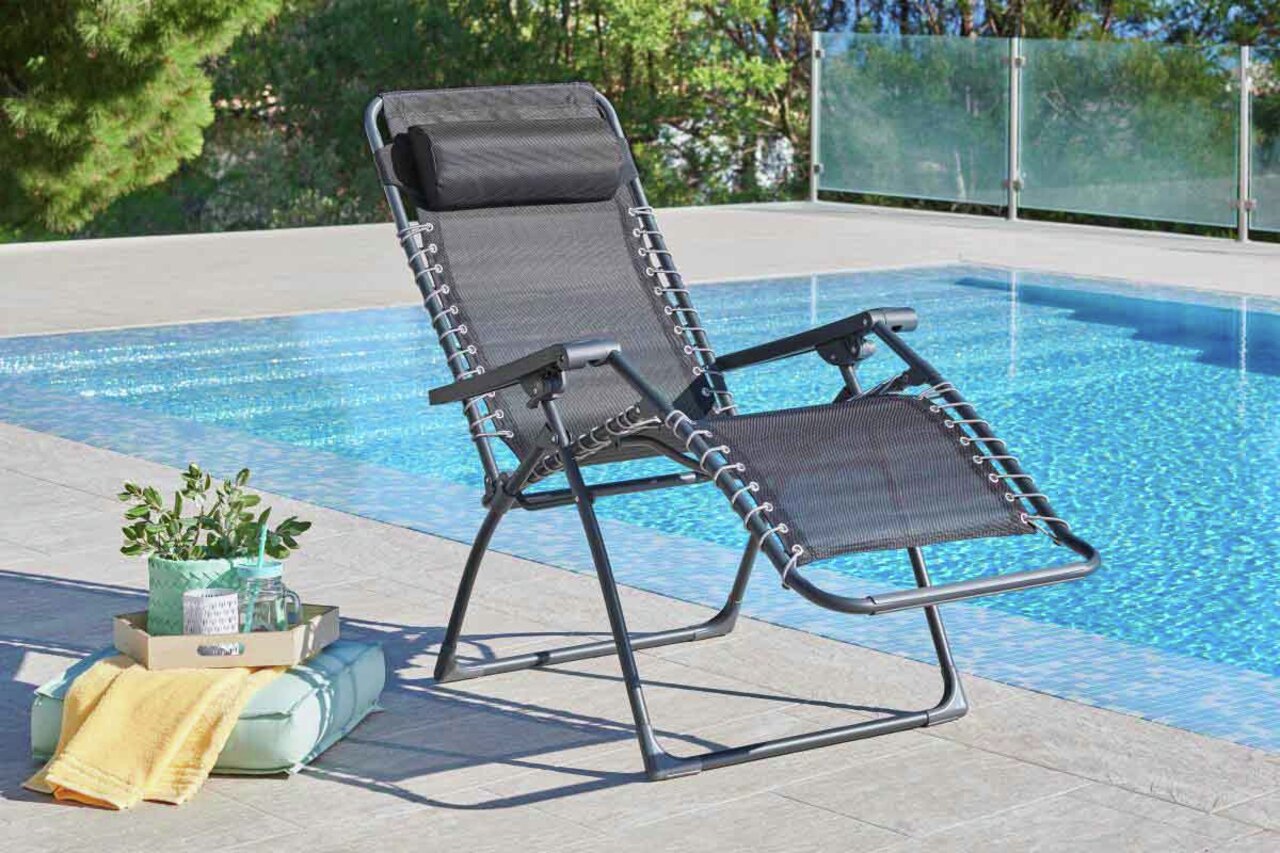 Gartenliege in schwarzer Farbe, aufgestellt neben einem Pool, mit Blick von der Seite.