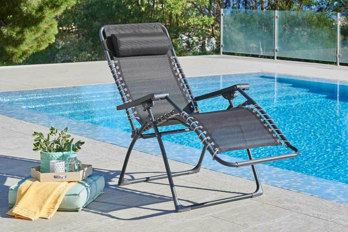 Gartenliege in schwarzer Farbe, aufgestellt neben einem Pool, mit Blick von der Seite.