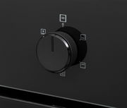 Nahaufnahme eines schwarzen Drehknopfs an einem Einbaubackofen, seitliche Perspektive