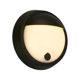 Runde, schwarze Akku-Außenwandleuchte mit leuchtendem, halbkreisförmigem Diffusor und sichtbarem Ein-/Ausschalter, seitliche Perspektive.