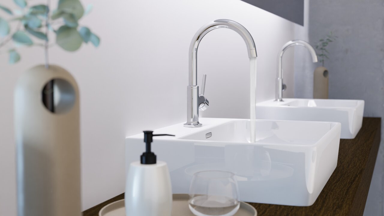 Moderne Waschtischarmatur in Seitenansicht mit fließendem Wasser, montiert auf einem weißen Waschbecken.