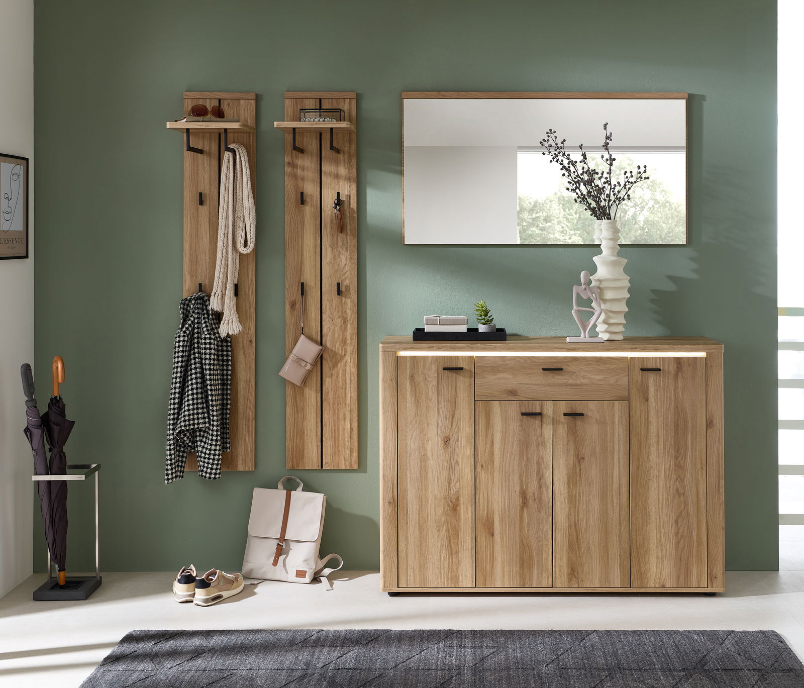 Voleo Garderoben-Set TINA Garderoben-Set aus Holz mit zwei Wandpaneelen, einem Spiegel und einem Sideboard, frontal betrachtet. Dekoriert mit Kleidung, Accessoires und Pflanzen.