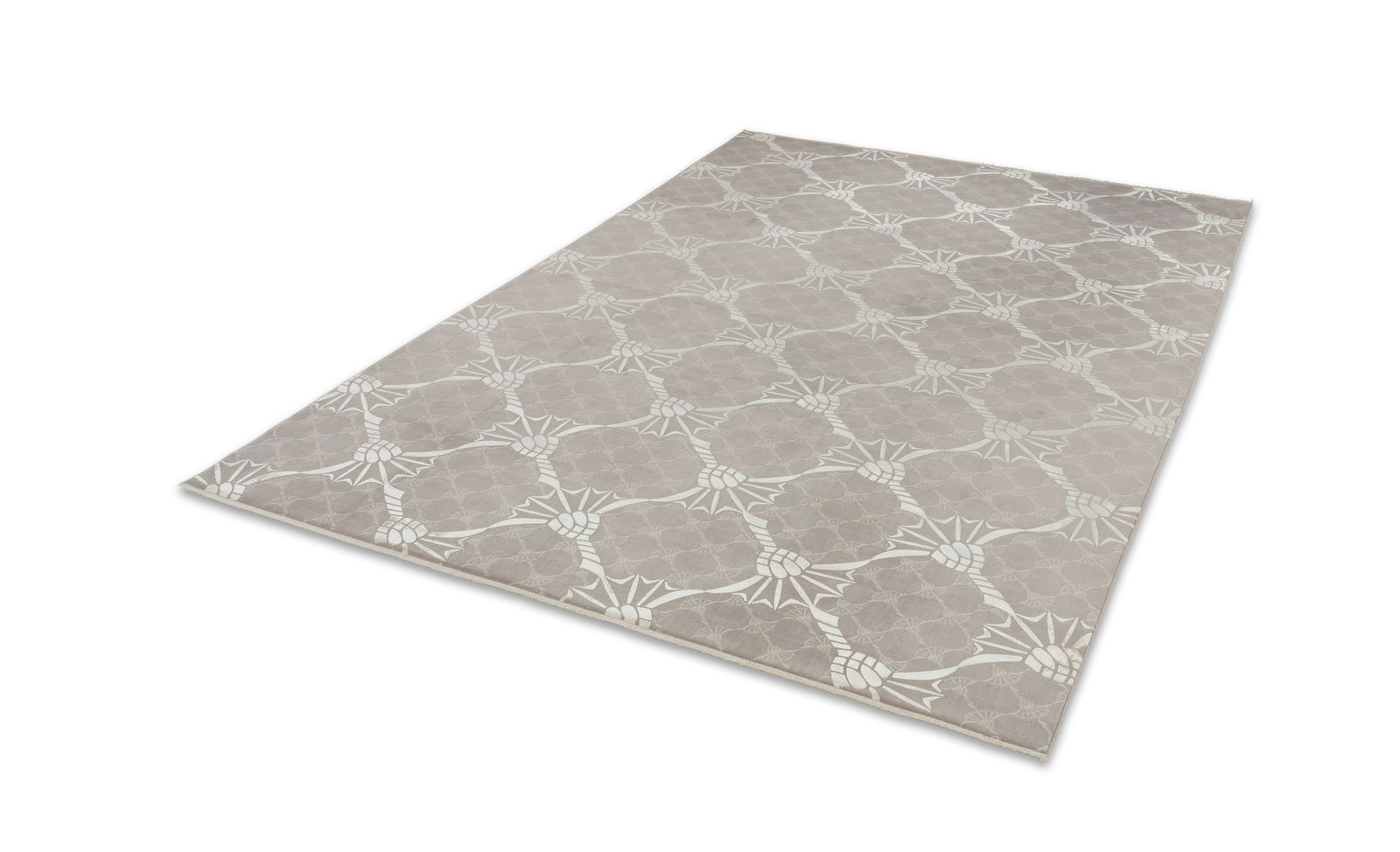 Teppich mit Kornblumenmuster in Grau und Weiß, schräg von oben fotografiert.