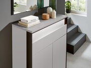 Moderner Schuhschrank in hellem Raum, seitliche Perspektive, dekoriert mit Büchern und Vasen.