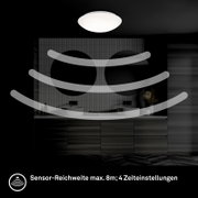 Witte plafondlamp met bewegingssensor in moderne badkamer boven dubbele wastafel, frontaal aanzicht; sensorbereik tot 8 m met 4 tijdsinstellingen.
