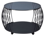 Moderner Couchtisch mit rundem Glasplatte und schwarzem Metallgestell, seitliche Perspektive.