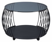 Moderner Couchtisch mit rundem Glasplatte und schwarzem Metallgestell, seitliche Perspektive.