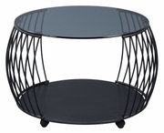 Moderner Couchtisch mit rundem Glasplatte und schwarzem Metallgestell, seitliche Perspektive.
