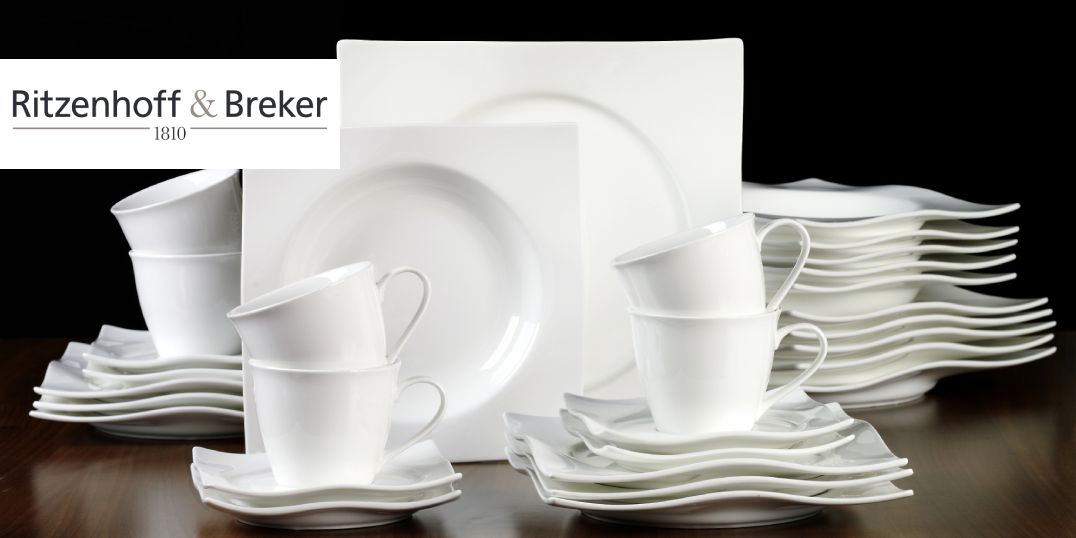Een elegant wit servies met borden, kopjes en schoteltjes in een golvend ontwerp.