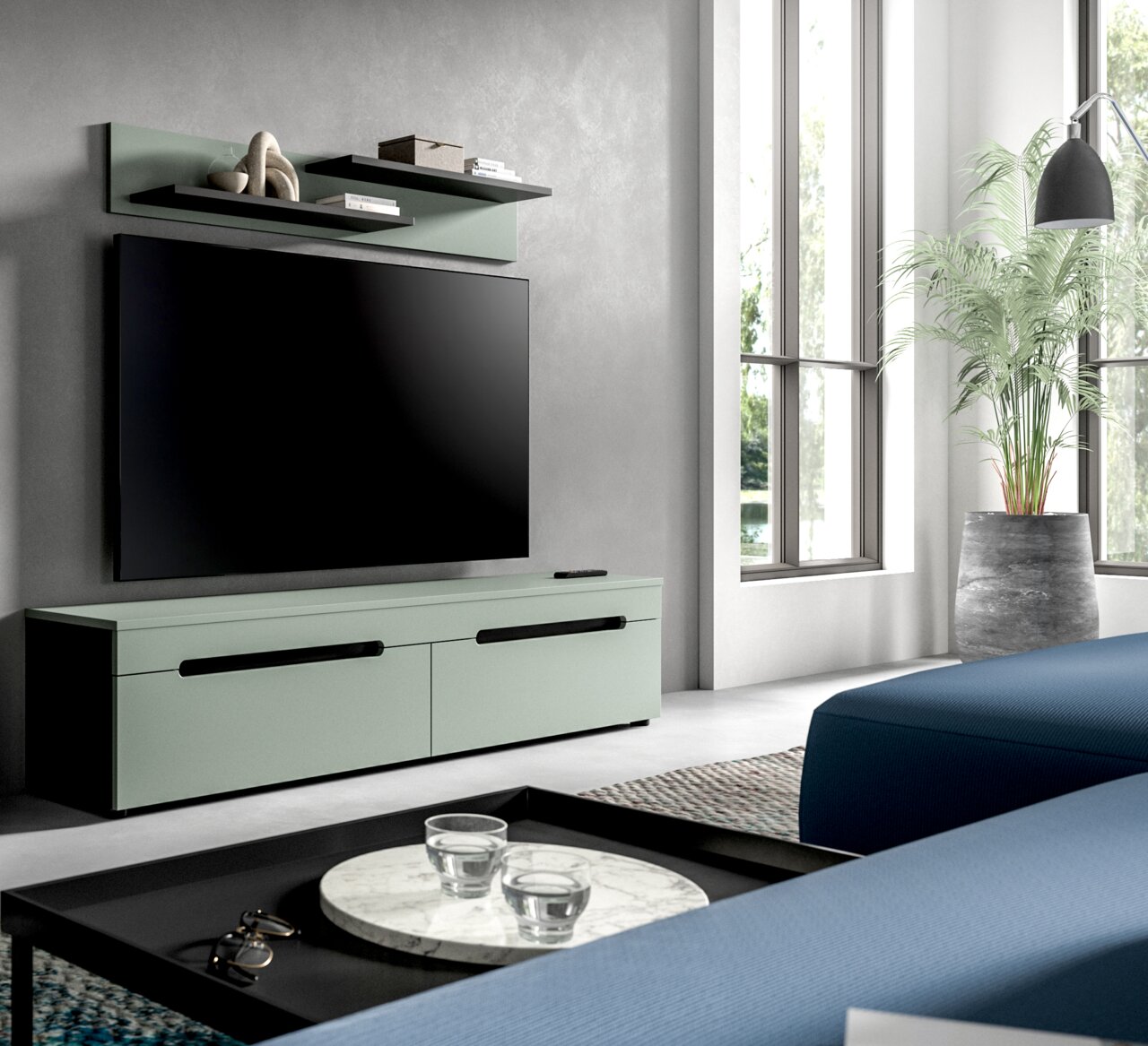 Modernes Wohnzimmer mit mintgrünem TV-Lowboard und Wandregal, großem Flachbildfernseher und schwarzen Griffen, fotografiert in leichter Seitenansicht von vorn