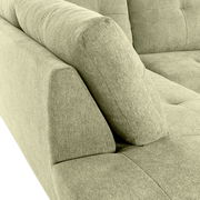 Nahaufnahme einer grünen Sofaecke mit gepolsterten Armlehnen und strukturiertem Stoffbezug, Perspektive von oben.