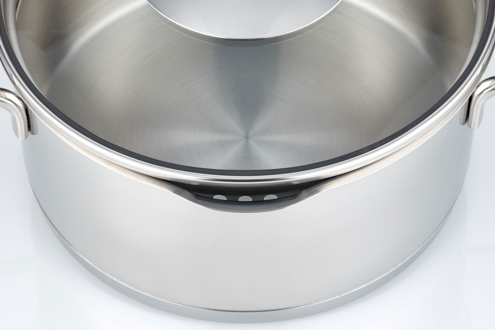 Nahaufnahme eines Edelstahltopfs mit Deckel, von oben betrachtet.