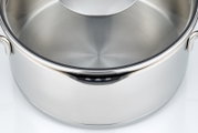 Close-up van een roestvrijstalen pan met deksel, gezien van bovenaf.