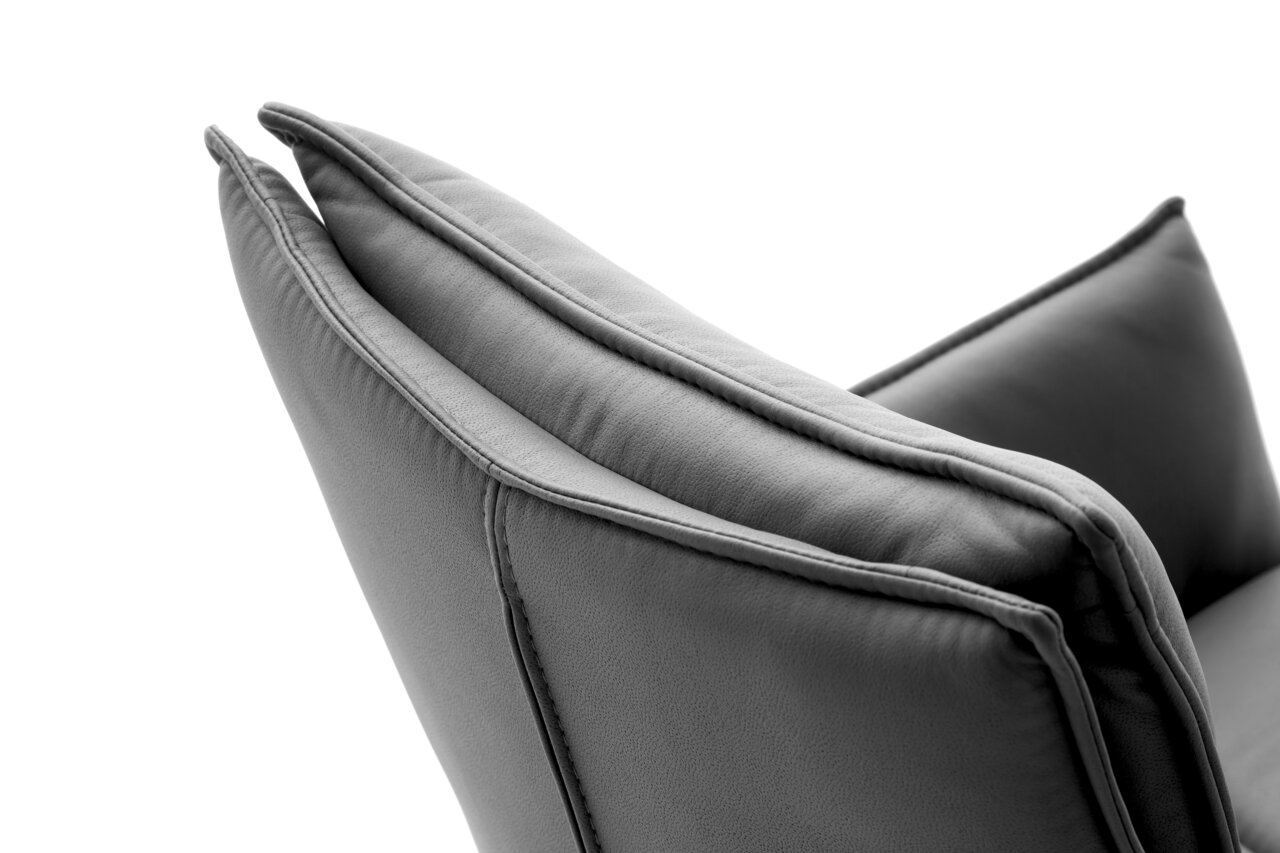 Nahaufnahme der Rückenlehne eines grauen Sessels aus Leder, seitliche Perspektive.
