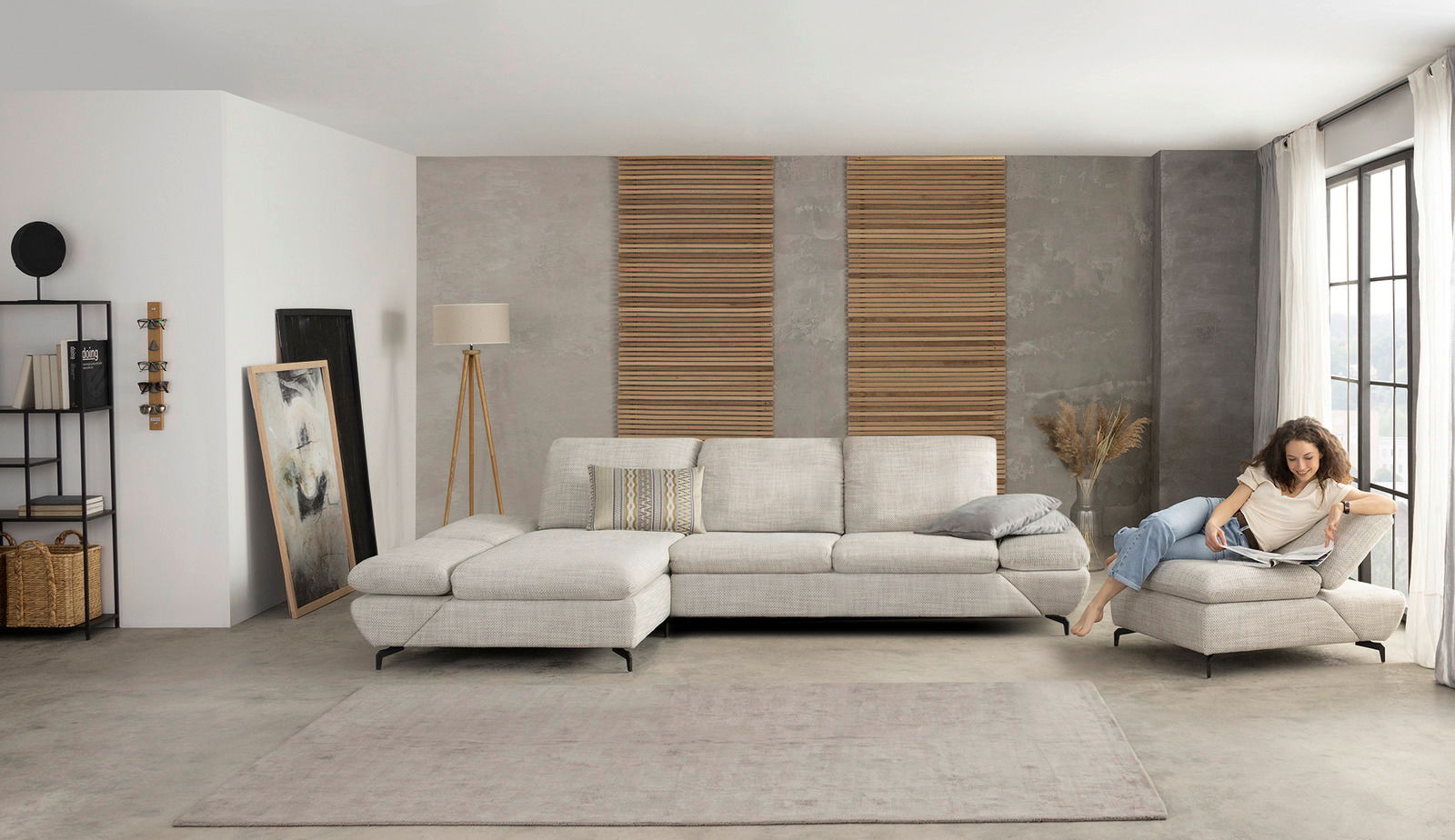 Moderne Longchairkombination in einem stilvollen Wohnzimmer, seitliche Perspektive mit einer Person, die auf dem Sofa entspannt liest.