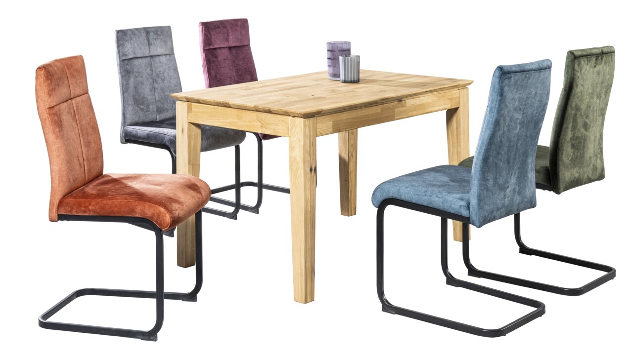 Novel Schwingstuhl GISMO Esszimmer mit einem Holztisch und fünf Schwingstühlen in verschiedenen Farben, seitliche Perspektive