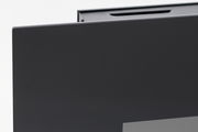 Nahaufnahme einer Ecke eines schwarzen Elektrokamins mit glatter Oberfläche, seitliche Perspektive.