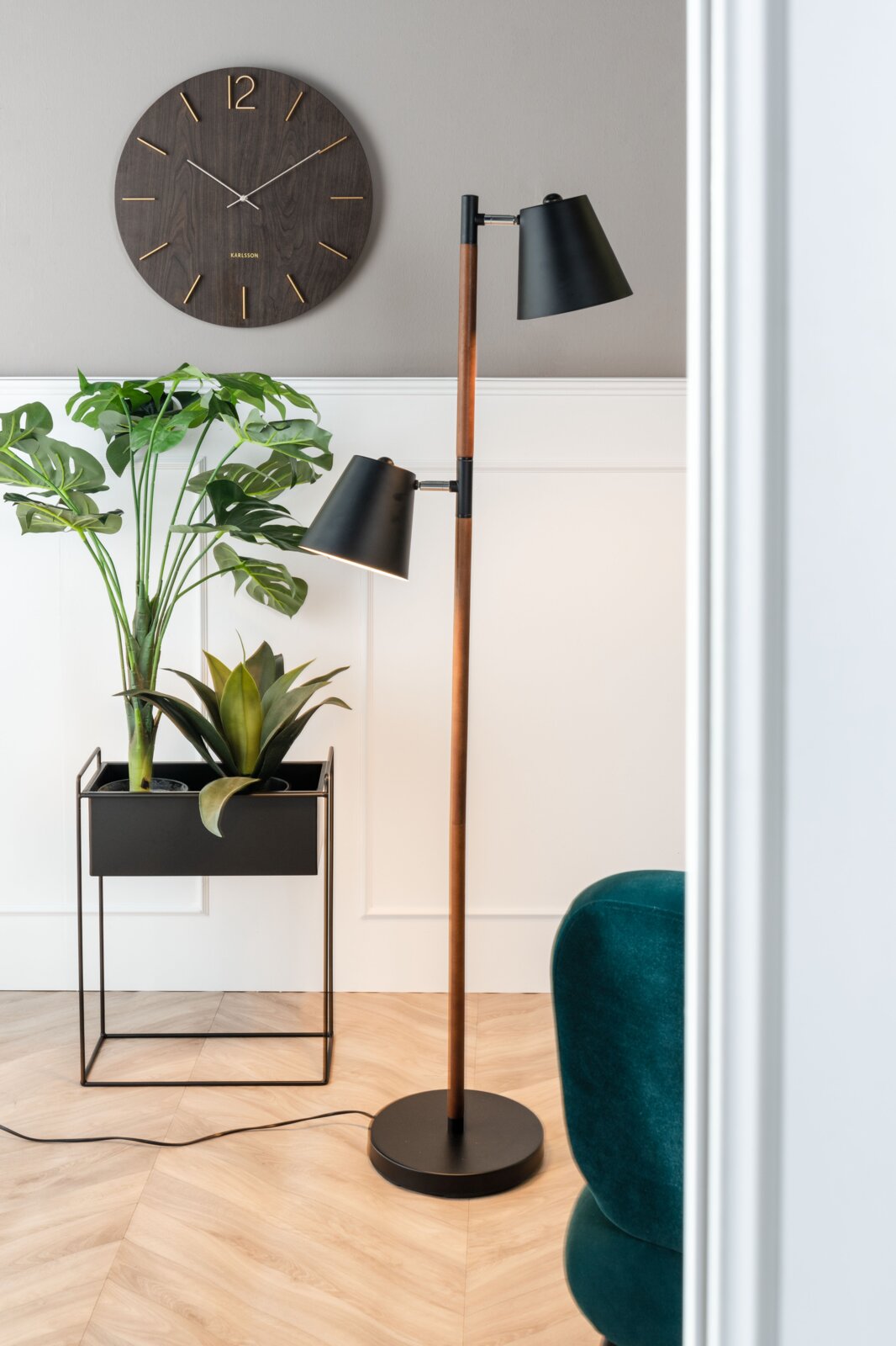 present time Pflanzgefäße-Set 2-tlg. ESSENCE Modernes Wohnzimmer mit einer Stehlampe, einem Pflanzgefäß-Set mit grünen Pflanzen und einer Wanduhr. Perspektive von der Seite.