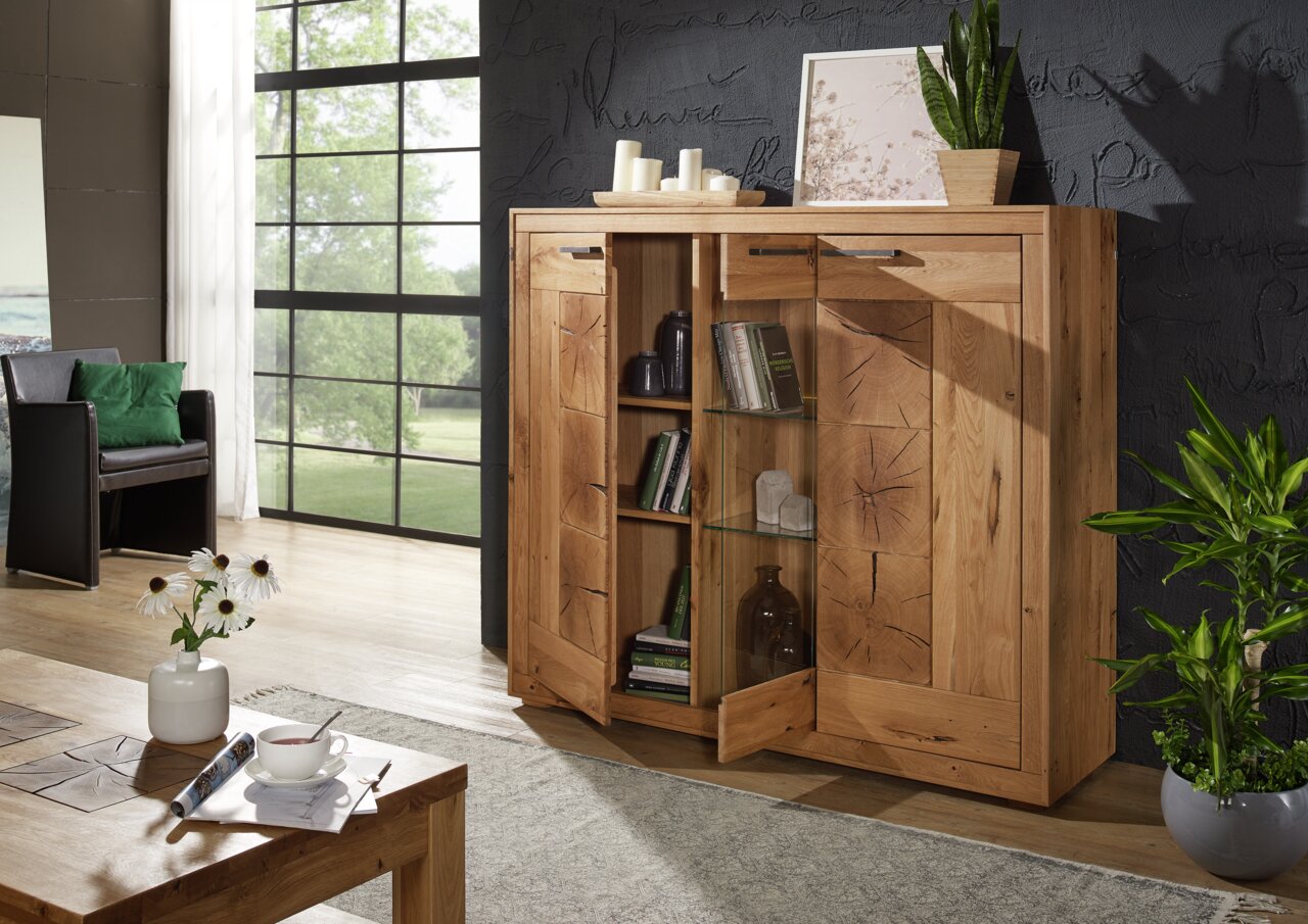 Hochwertiges Highboard aus Holz mit geöffneter Tür, das Bücher und Dekorationen zeigt. Perspektive von vorne rechts.
