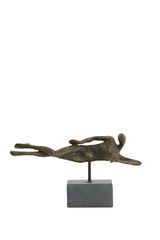 Bronzefarbene Skulptur eines liegenden Menschen auf einem Sockel, seitliche Perspektive