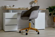 Grauer Bürostuhl mit goldenen Beinen und Rollen, seitliche Perspektive, vor einem modernen Schreibtisch mit weißen Schubladen.
