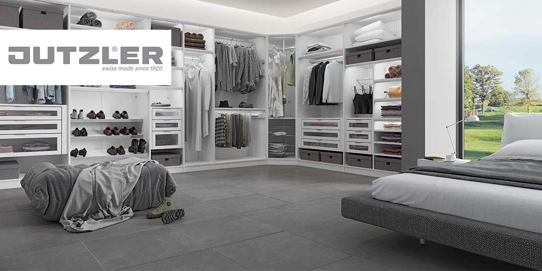 Helles Schlafzimmer mit einem geräumigen, organisierten Kleiderschrank, in dem Kleidung und Schuhe ordentlich angeordnet sind.