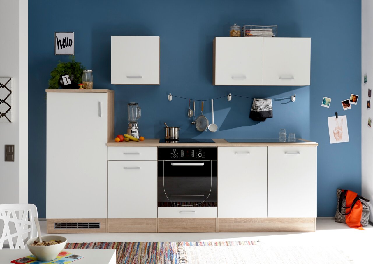 Yourkitchen Unterschrank ANDY Moderne Küchenzeile mit weißen Schränken und Holzarbeitsplatte, frontal fotografiert vor einer blauen Wand.