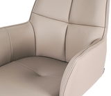 Nahaufnahme eines beigen Armlehnstuhls Novel MIAMI mit weicher Polsterung und eleganten Nähten, seitliche Perspektive.