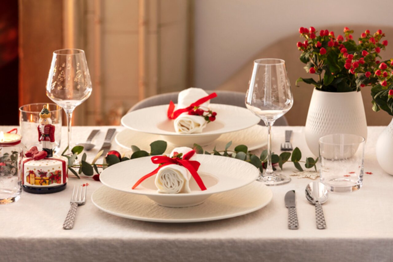 Elegantes Tischgedeck mit zwei Weißweinkelchen in einem festlichen Ambiente, seitliche Perspektive.
