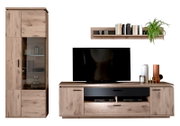 Wohnwand im Eiche-Optik-Design mit hoher Vitrine mit Glastür, TV-Lowboard mit schwarzen Fronten und Wandregal mit Büchern und Pflanze, frontal aus leicht erhöhter Perspektive